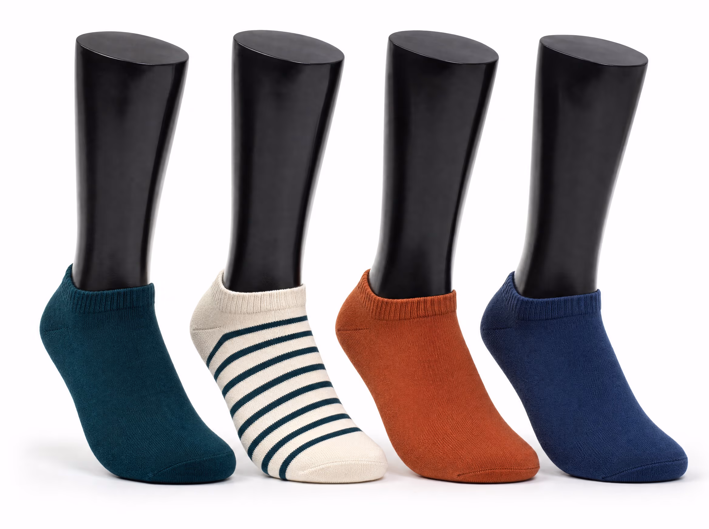 Four glossy black sock display forms, each wearing a low ankle sock in a different colorway: deep teal, cream with teal stripes, terracotta, and navy, on a white background