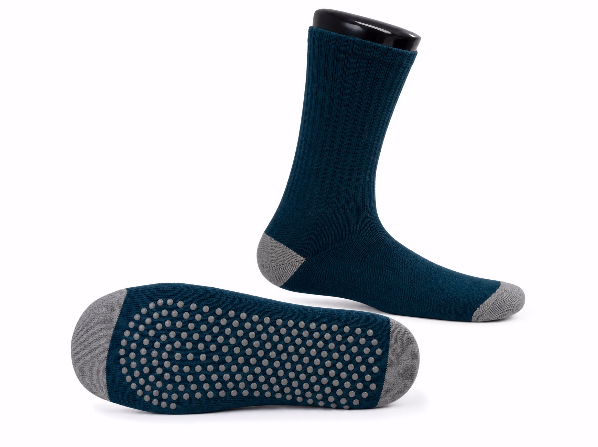 A deep-teal grip sock shown two ways: worn in profile at crew height, and flipped sole-up to show the full-sole silicone grip dots, on a white background