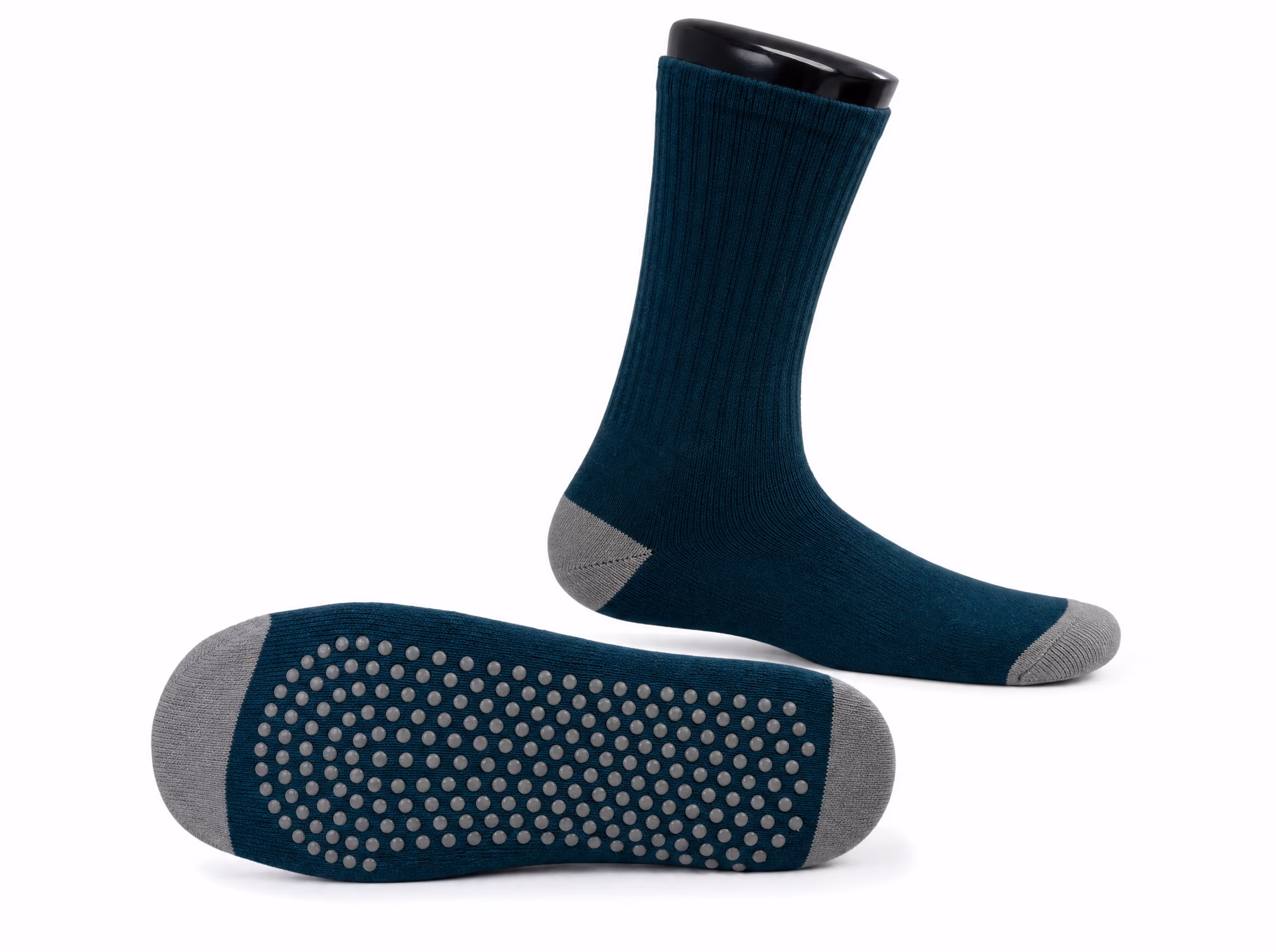 A deep-teal grip sock shown two ways: worn in profile at crew height, and flipped sole-up to show the full-sole silicone grip dots, on a white background