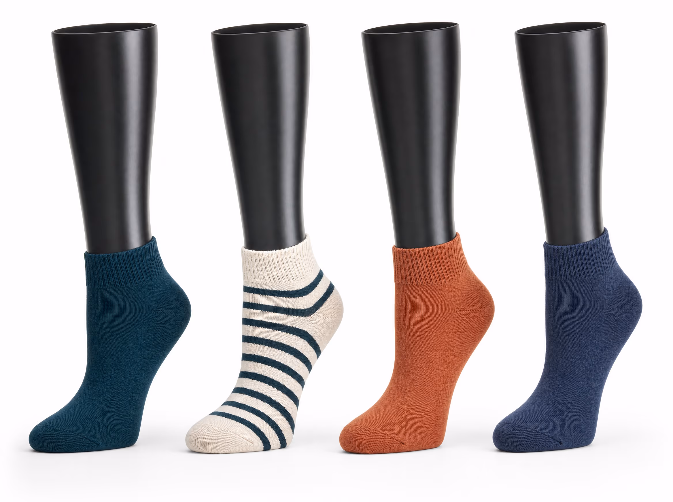 Four glossy black sock display forms, each wearing a quarter-height sock in a different colorway: deep teal, cream with teal stripes, terracotta, and navy, on a white background