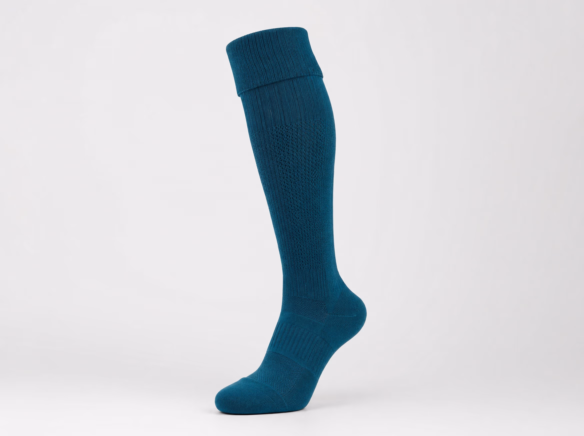 A single deep-teal over-the-calf soccer sock shown standalone on a white studio background, with a ribbed fold-over cuff and reinforced heel and toe